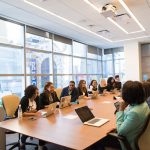 A large meeting at a conference table where employees discuss capacity utilization.